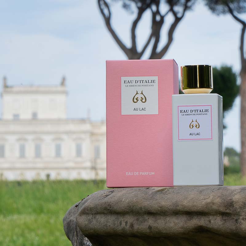 Lifestyle shot of Eau d&#39;Italie Au Lac Eau de Parfum Spray (100 ml) and box with a manor and trees in the background