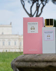 Lifestyle shot of Eau d'Italie Au Lac Eau de Parfum Spray (100 ml) and box with a manor and trees in the background