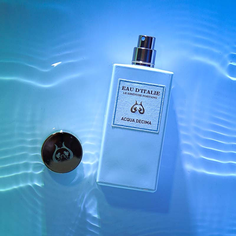 Lifestyle shot top view of Eau d&#39;Italie Acqua Decima Eau de Parfum Spray (100 ml) in water with blue background