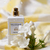 Lifestyle shot of Eau d'Italie Fior Fiore Eau de Parfum Spray (100 ml) with white flowers in the foreground and water splashing