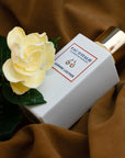 Lifestyle shot of Eau d'Italie Jasmine Leather Eau de Parfum Spray (100 ml) on brown fabric with jasmine flower