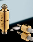 Chantecaille Gold Recovery Intense Concentrate P.M. showing one vial open with dropper and product droplets