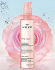 Nuxe Very Rose Delicate Cleansing Oil bottle in front of rose
