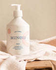 Lifestyle shot of Minois Paris Lait Corps (Body Lotion) (500 ml) with cloth in the background