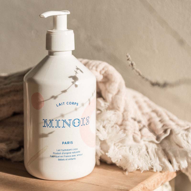 Lifestyle shot of Minois Paris Lait Corps (Body Lotion) (500 ml) with blanket in the background