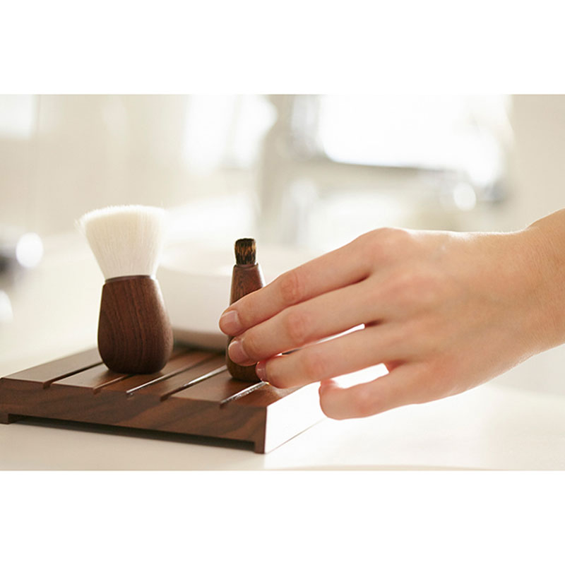 Shaquda SUVE Nose Cleansing Brush pictured in model's hand beside face brush - not included