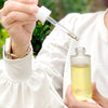 Athar’a Pure Neem Healing Oil in model's hands with dropper