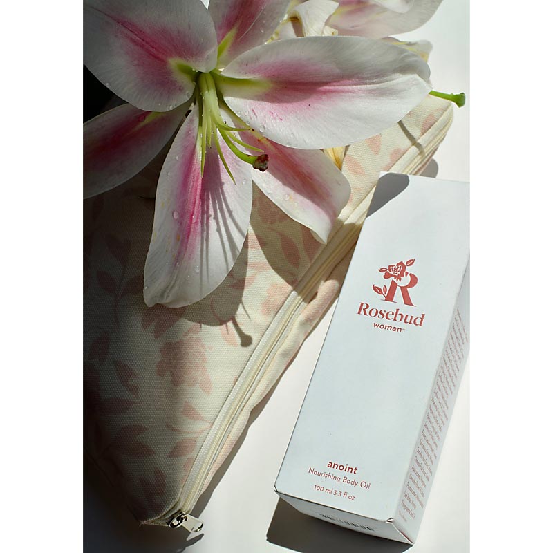 Rosebud Woman Anoint Nourishing Body Oil beauty shot with flower and bag (not included)