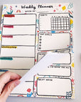 Abbie Ren Illustration Weekly Planner Notepad showing model's hand turning the page
