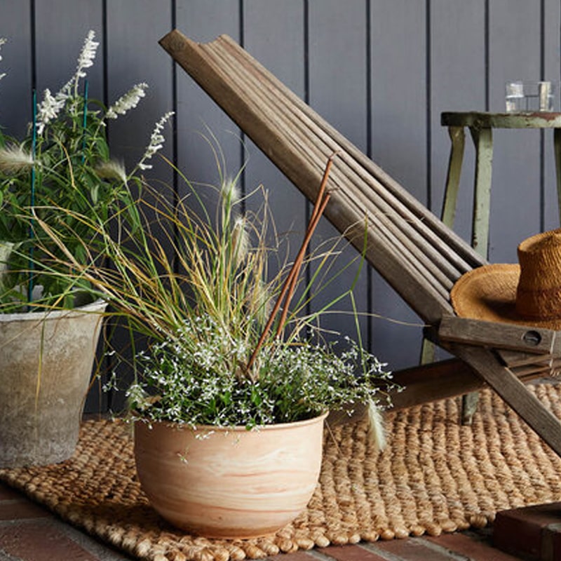 The Floral Society Sage, Coffee, Cinnamon Leaf & Cedarwood Outdoor Incense shown placed in planter (not included)