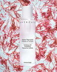 Chantecaille Purifying and Exfoliating Phytoactive Solution beauty shot with pink flowers in background