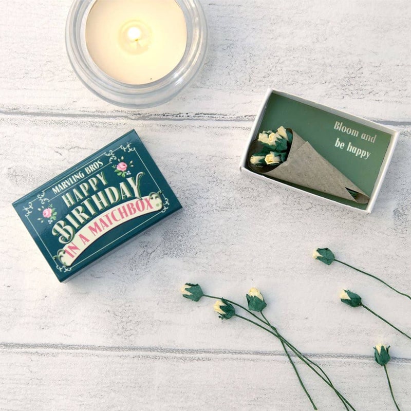 Marvling Bros Ltd Happy Birthday Folk Art Mini Bouquet In A Matchbox showing open box by a lit candle