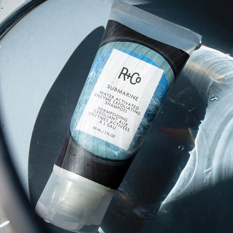 R+Co Submarine Water Activated Enzyme Exfoliating Shampoo shown under water