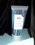 Beauty Shot of R+Co Velvet Curtain Cotton Touch Texture Balm in front of a black Velvet Curtain