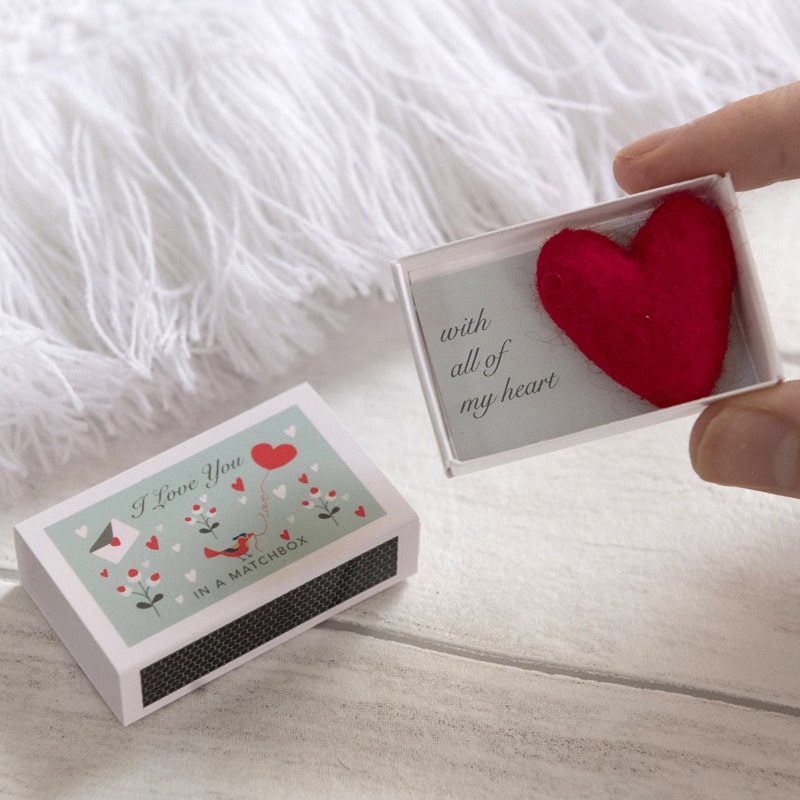 Lifestyle shot of Marvling Bros Ltd Wool Felt Heart And Love Message In A Matchbox shown with box open showing heart, in models hand