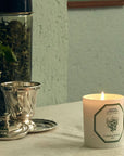 Lifestyle shot of Carriere Freres Verbena Candle showing candle lit with teapot and cup in background