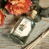 Lifestyle top view shot of Carriere Freres Rose Amber Diffuser shown with diffuser sticks and roses in background