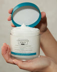 Christophe Robin Cleansing Purifying Scrub with Sea Salt  showing model holding open jar