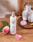 Christophe Robin Instant Volume Mist with Rose Extracts shown on a counter with a rose and vase in background