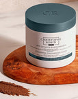 Christophe Robin Cleansing Thickening Paste for Men showing on a slab of wood with a product smear showing color and texture
