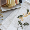 June & December Herbal Tea Garden Napkins Set - lifestyle shot showing napkin beside bars of soap (not included)