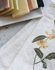 June & December Herbal Tea Garden Napkins Set - lifestyle shot showing napkin beside bars of soap (not included)