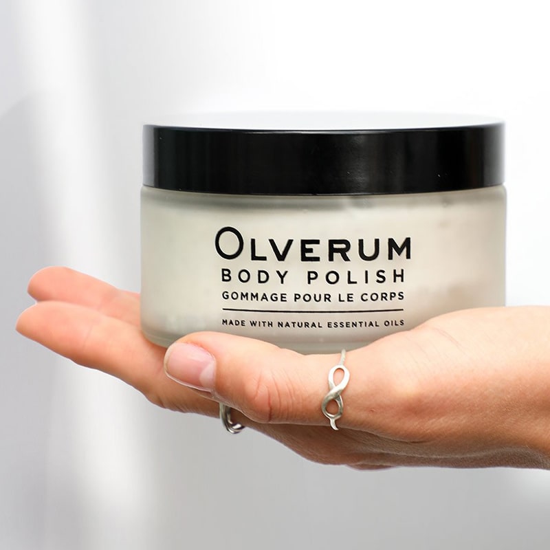 Olverum Body Polish closed jar shown in model&#39;s open palm