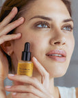 Olverum Pure Radiance Facial Oil showing model holding bottle beside face