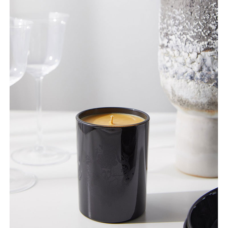 Harris Reed Palo Santo Epilogue Candle lifestyle shot of candle with wine glasses