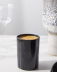 Harris Reed Palo Santo Epilogue Candle lifestyle shot of candle with wine glasses