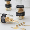 Studio Carta Gold Paper Clips showing multiple jars, one tipped over with clips spilling out