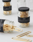 Studio Carta Gold Paper Clips showing multiple jars, one tipped over with clips spilling out