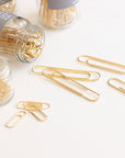 Studio Carta Gold Paper Clips showing multiple jars and some spilled out