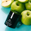 Odacite Green Smoothie Quenching Creme leaning against green apples