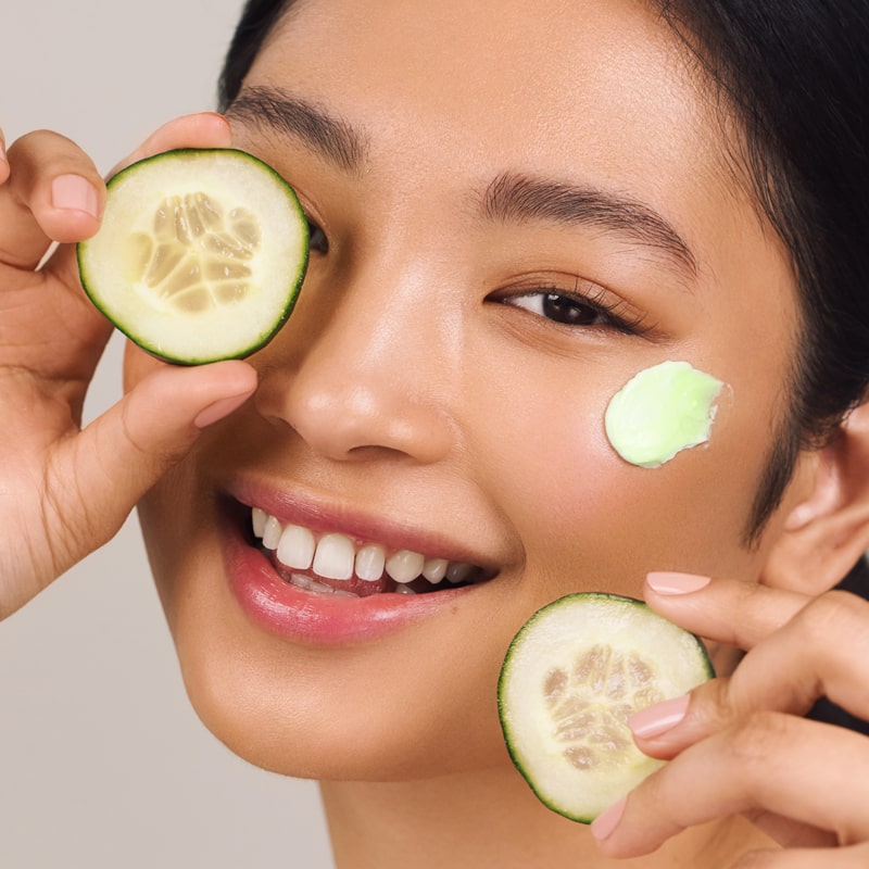 Odacite Green Smoothie Quenching Creme shown on model&#39;s face with cucumber slices