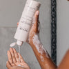 Neom Organics Super Shower Power Body Cleaner pouring on model hands 