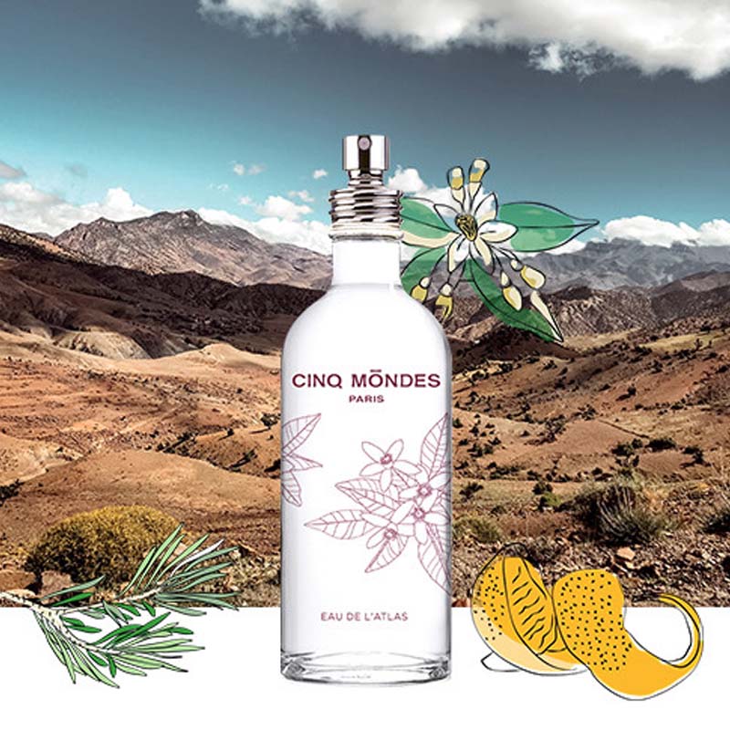 Lifestyle shot of Cinq Mondes Eau de L’Atlas Fresh Aromatic Mist (3.4 oz) with mountain landscape in the background and illustrations of ingredients in the foreground