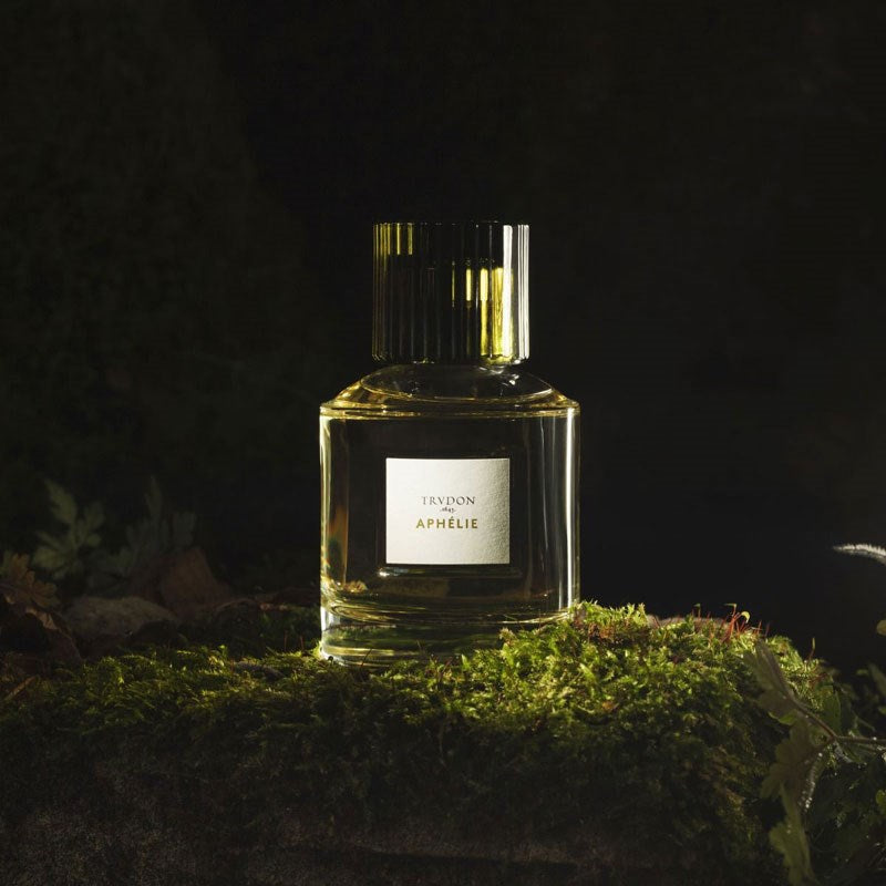 Cire Trudon Aphelie Eau de Parfum dramatic beauty shot of bottle on mossy rock with dark background