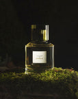 Cire Trudon Aphelie Eau de Parfum dramatic beauty shot of bottle on mossy rock with dark background