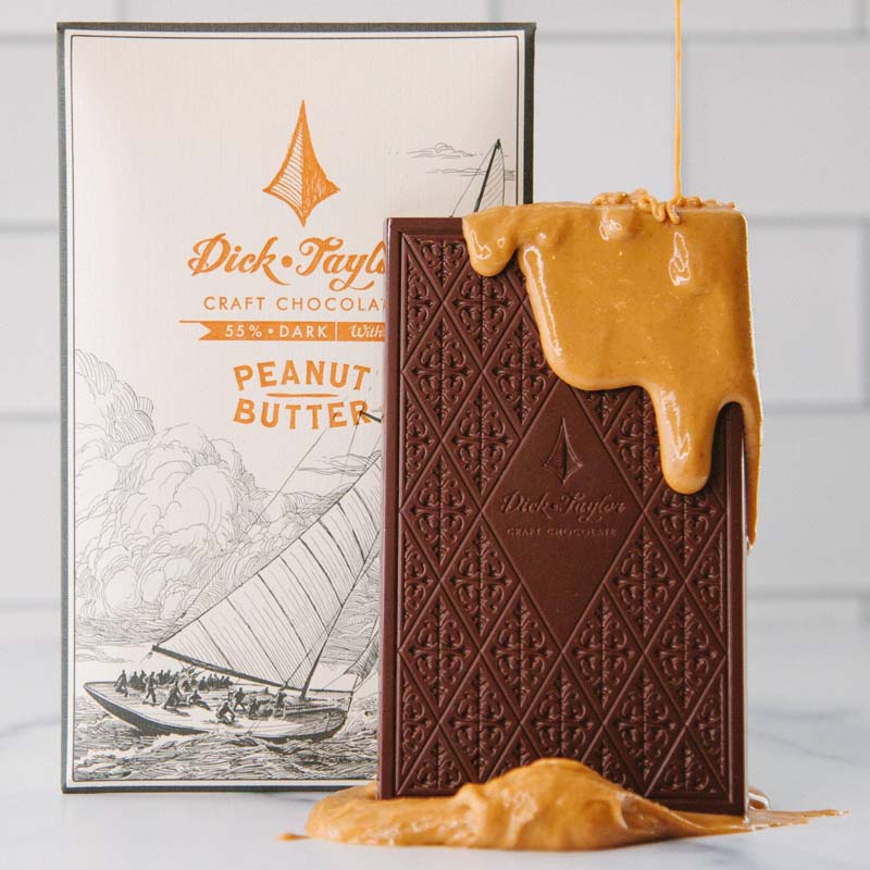 Beauty Shot of Dick Taylor Craft Chocolate Peanut Butter Dark Chocolate showing bar of chocolate with peanut butter dripping down it and under it
