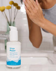 Ursa Major Making Moves Milky Cleanser showing on counter with model washing face