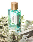 Lifestyle shot of Goldfield & Banks Pacific Rock Moss Perfume 100 ml on stone slab with white flowers in the background and foreground