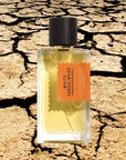 Mood shot of Goldfield & Banks White Sandalwood Perfume 100 ml with extremely dry and cracked landscape in the background