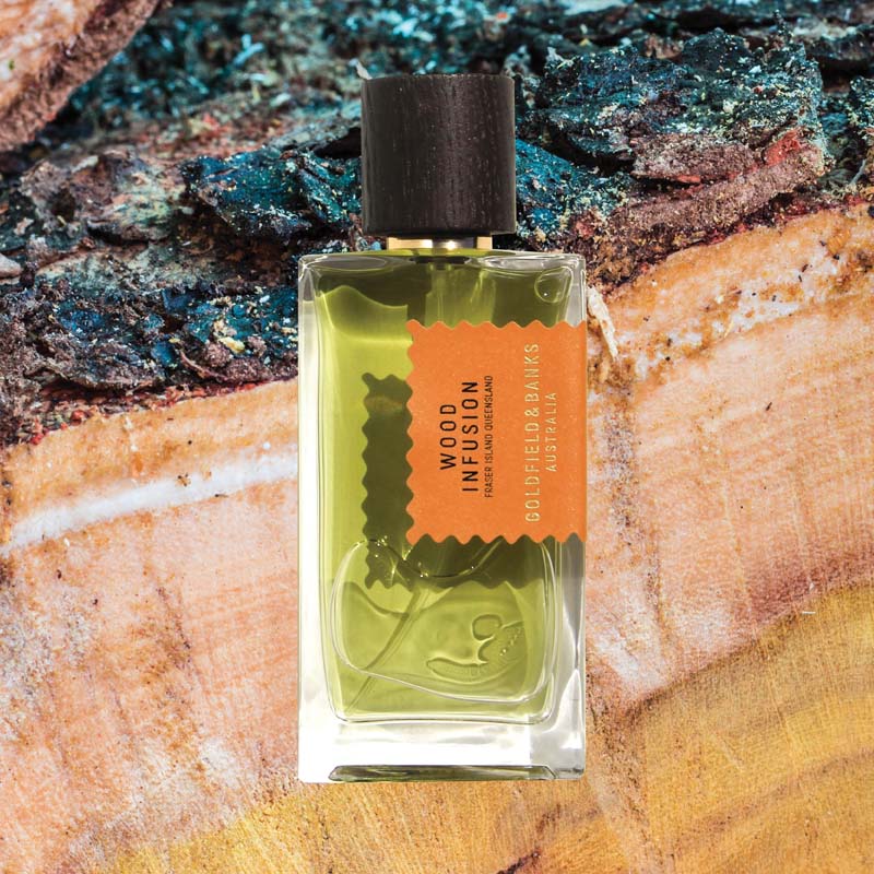 Mood shot of Goldfield &amp; Banks Wood Infusion Perfume 100 ml with wood in the background