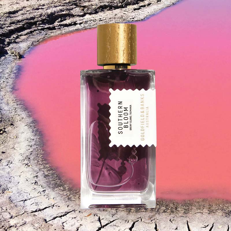 Mood shot of Goldfield & Banks Southern Bloom Perfume 100 ml with pink water in the background and dried landscape