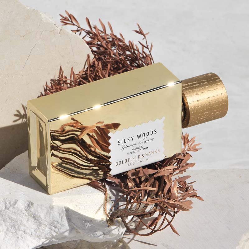 Beauty shot of Goldfield &amp; Banks Silky Woods Perfume 100 ml on stone slab with botanical element in the background
