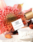 Beauty shot of Goldfield & Banks Sunset Hour Perfume 100 ml on stone slabs with large pink flower in the background