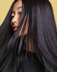 Oribe Hair Alchemy Resilience Shampoo with dark hair