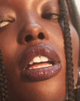 Close up of Roen Beauty Kiss My Lip Balm – Scout on model with dark skin tone
