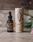 MOA Aphrodite Organic Facial Oil showing on a counter with a rose and plant